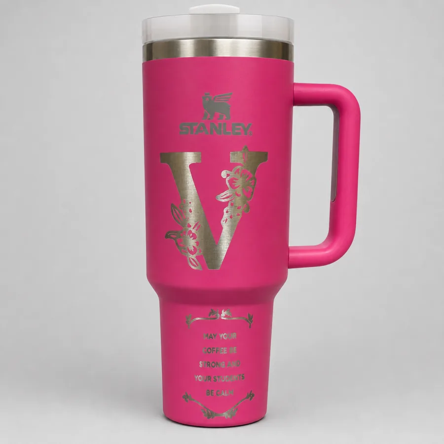 Bright pink handled tumbler engraved with a floral letter V and a teacher appreciation message